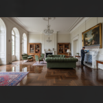 Professional technicians using specialized equipment to dry and restore water-damaged luxury hardwood floors and a Persian rug in a Houston estate.