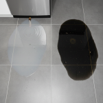 Pooling contaminated water on a floor, indicating potential Category 3 biohazard and the urgency for Houston water damage remediation.