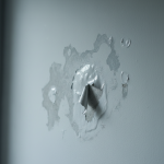 Close-up of a residential wall showing severe paint blistering and discoloration, visually demonstrating symptoms of hidden moisture and thermal inertia discussed in 'Why Do My Walls Look Wet? Thermal Inertia & Paint Blistering'.
