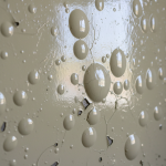 Close-up of a glossy painted wall showing prominent blisters and bubbling, indicating trapped moisture and potential hidden water damage. Our experts use thermal inertia principles to detect these concealed leaks, especially when glossy paint acts as a vapor barrier.