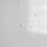 Close-up of a wall with high-gloss paint visibly blistering and peeling, indicative of severe trapped moisture and water damage. This requires urgent water damage restoration in Houston, TX.