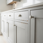 Close-up of kitchen cabinets showing severe water damage, including swollen wood, peeling laminate, and dark discoloration. This visible damage is crucial when navigating 'Line of Sight' insurance claims for a full matching set of kitchen cabinets.