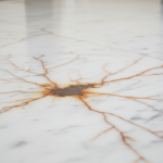 Close-up of white Carrera marble countertop with distinct orange-brown rust stains caused by iron oxidation from water damage, illustrating the article's focus on marble rust removal.