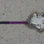 A specialist precisely testing concrete slab pH levels with a liquid kit, indicating alkalinity for flooring installation stability.