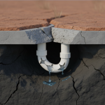 Gumbo clay soil expansion breaking plumbing pipe