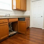 Tenant documenting water damage from appliance leak in Houston apartment kitchen